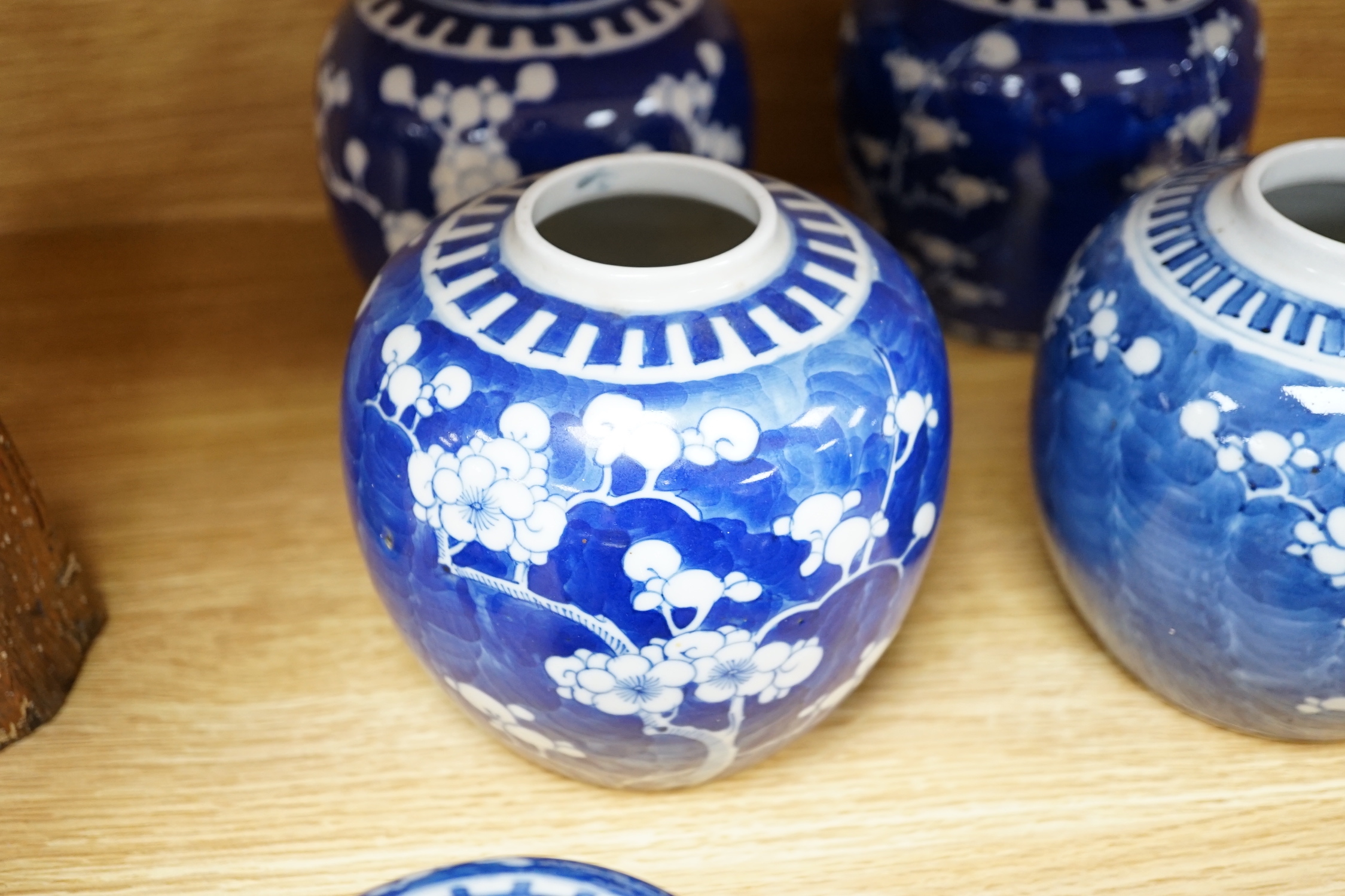 Five Chinese blue and white prunus ginger jars, one with cover- 15cm high and another jar